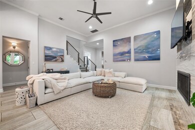 Living room with ceiling fan, stairs, baseboards,