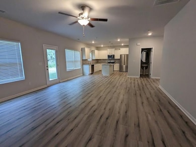 Unfurnished living room featuring visible vents, b