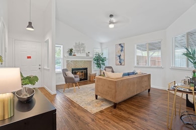 Living room with ceiling fan, a tile fireplace, d