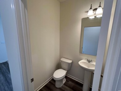 Bathroom with toilet, sink, and wood-type flooring