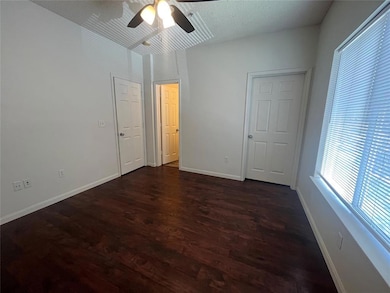 Unfurnished bedroom with dark wood-style flooring and ceiling fan