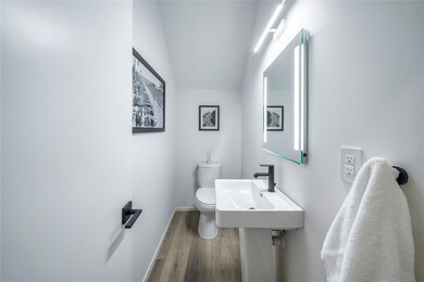 Bathroom featuring a sink, wood finished floors, t