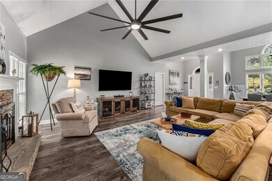 Living room featuring high vaulted ceiling, ceiling fan, a fireplace, recessed lighting, and dark wood-style flooring