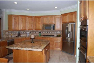 Gourment kitchen with granite counters, large center island, stainless steel appliances, wine chiller, breakfast area and pantry.