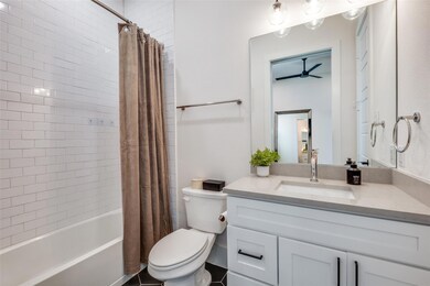 Full bathroom with vanity, ceiling fan, toilet, an