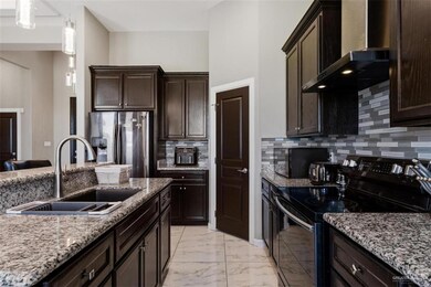 Kitchen, stainless steel refrigerator with ice dispenser, range with electric stovetop, tiled marble finish look  floor, and a sink