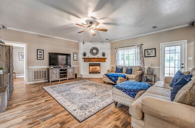 Living room with a fireplace, crown molding, light