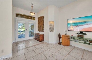 Entrance foyer with french doors and light tile pa