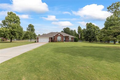Ranch-style home featuring a garage and a front ya