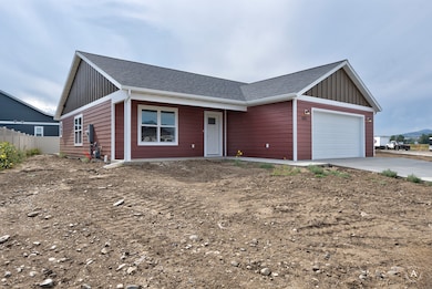 Ranch-style house with an attached garage, roof with shingles, driveway, and board and batten siding