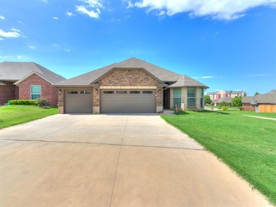View of front of home with concrete driveway, a garage, a front yard, and brick siding