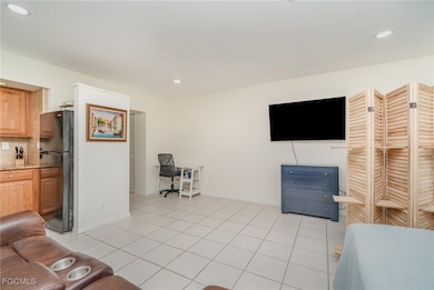 Living area featuring a desk, light tile patterned floors, and recessed lighting