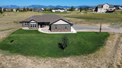 View of front facade featuring a mountain view, a residential view, stone siding, and driveway