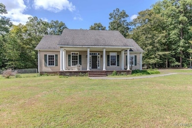 Cape cod home featuring a porch and a front yard