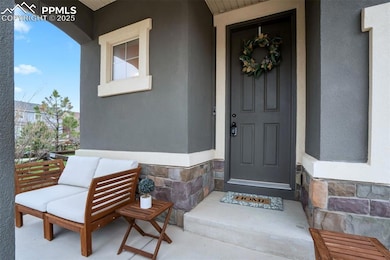 View of exterior entry with a porch, stone siding,
