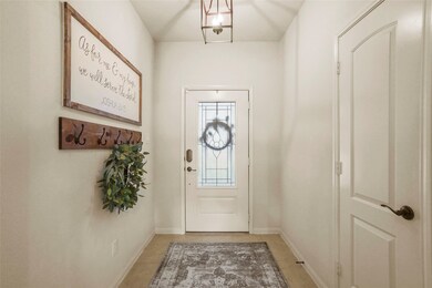 Just inside the front door is a welcoming formal entry with a simple yet elegant fixture.
