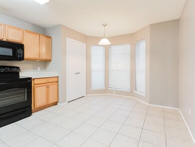 Kitchen featuring light brown cabinetry, black app