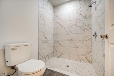 Bathroom featuring a tile shower and toilet
