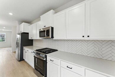 Featuring stainless appliances, quartz countertops and tile backsplash, the kitchen is sure to impress! Similar home shown. Color and finish may vary.