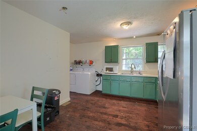 Kitchen with washer and dryer, sink, green cabinet