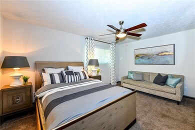 Bedroom with dark colored carpet and ceiling fan