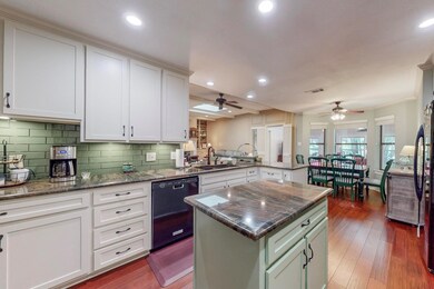 Island Kitchen featuring Shaker Cabinets, Bamboo wood flooring, dishwasher, decorative backsplash, Natural stone counters, undercabinet lighting