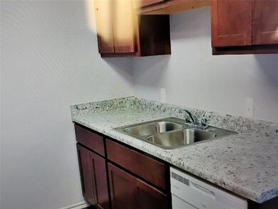 Kitchen featuring white dishwasher and a sink