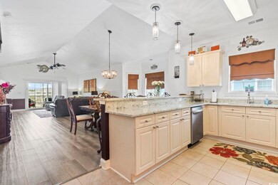 Kitchen featuring light stone countertops, hanging light fixtures, plenty of natural light, and lofted ceiling