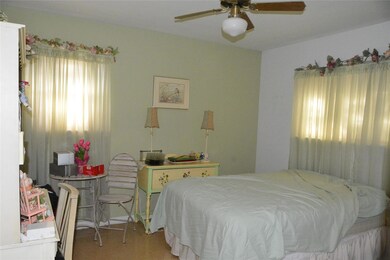 Carpeted bedroom featuring ceiling fan