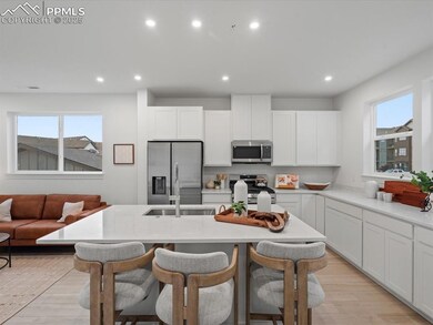 Kitchen with appliances with stainless steel finishes, light wood-type flooring, an island with sink, a breakfast bar, and recessed lighting