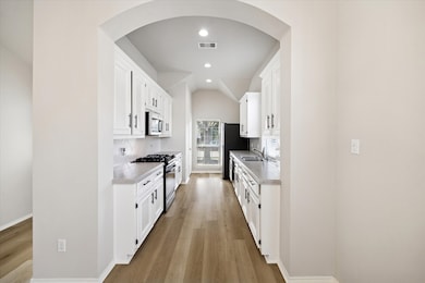 This bright and, upgraded kitchen shines with stunning white cabinets, modern backsplash, and sleek countertops. The perfect space for cooking and entertaining.