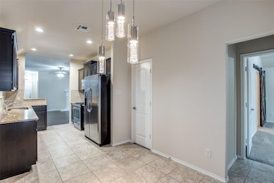 Kitchen with light stone counters, appliances with stainless steel finishes, decorative backsplash, recessed lighting, and light tile patterned floors