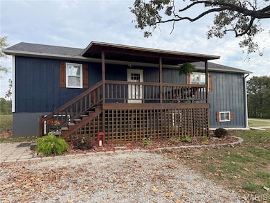 View of front of house featuring stairway and a shingled roof