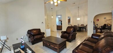 Spacious living room with high ceilings, tiled flo