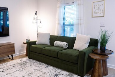 Living area with baseboards and wood finished floors