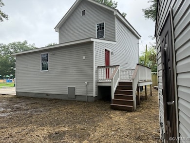 Back of property with a wooden deck and stairs