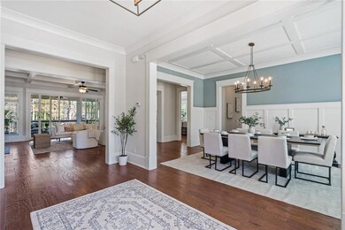 Dining space featuring a wainscoted wall, coffered