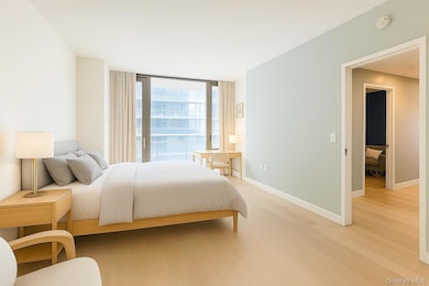 Bedroom with expansive windows and light wood-style flooring