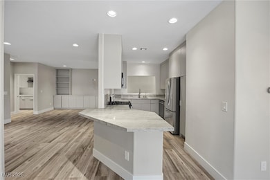 Kitchen with a peninsula, a sink, light wood-type
