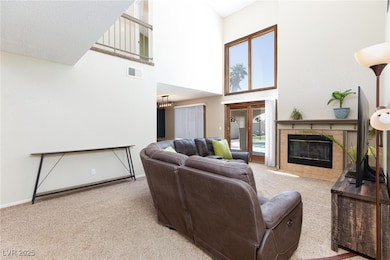 Carpeted living area with a tile fireplace, a towe