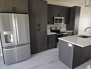 Kitchen featuring sink, dark brown cabinetry, and stainless steel appliances