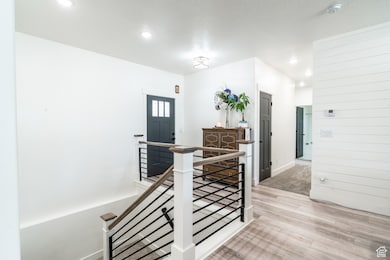 Foyer with light wood finished floors, recessed lighting, and a textured ceiling