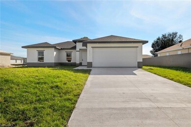 View of front facade featuring a garage and a front lawn