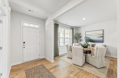 Foyer entrance with light wood finished floors and recessed lighting