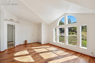 Unfurnished living room with vaulted ceiling and light wood-style flooring