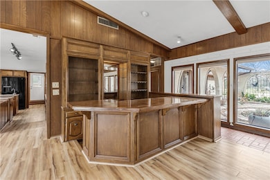 Kitchen with wooden walls, light wood-type floorin