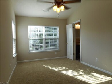 Master Bedroom: Room features include carpet flooring, three windows for natural light, raised ceiling with plant or decorations shelf on the top side of the wall behind us, and a ceiling fan with light. The open door to right is the master bathroom and there is a nice walk-in-closet on the right side just out of sight.