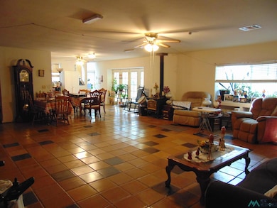 Living area with tile patterned flooring, healthy amount of natural light, and a ceiling fan