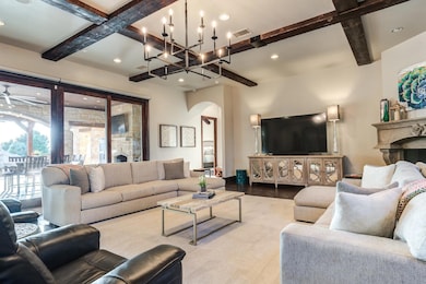 Great Room is Adorned with Beams and View of Outdoor Living