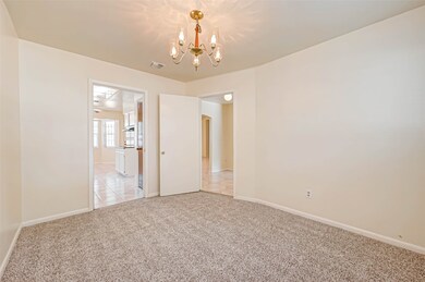 The formal dining room is a sophisticated and inviting space designed for hosting elegant meals and special gatherings. One of its most striking features is the chandelier that hangs from the ceiling, serving as the room's centerpiece.